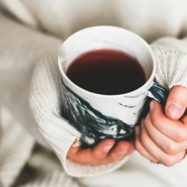Zwei Hände um eine warme Tasse